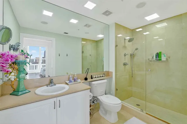 a bathroom with a sink a toilet a shower and a mirror