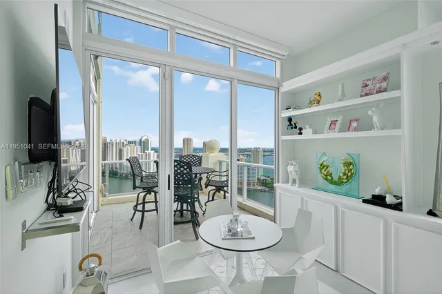 a dining room with furniture and a floor to ceiling window