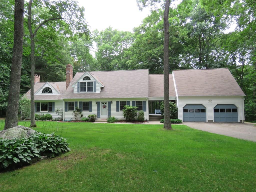 a front view of a house with a garden and trees