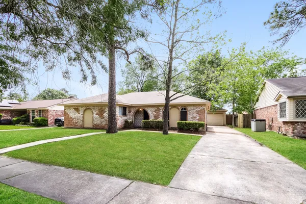 a front view of a house with a yard and trees