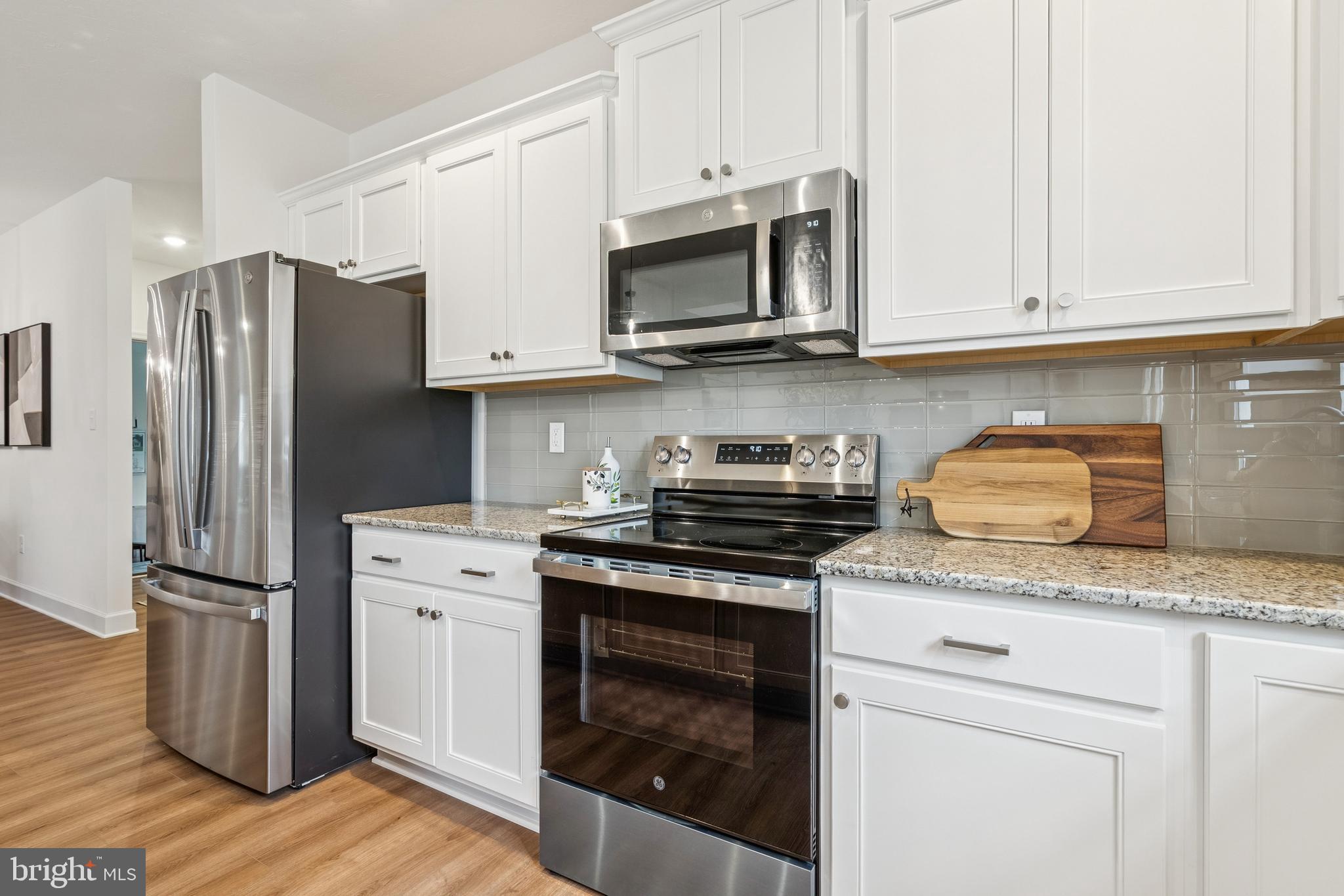 136 Piedmont Way, Unit 102 Hanover, PA 17331 - Photo 13 of 40 a kitchen with granite countertop cabinets stainless steel appliances and wooden floor