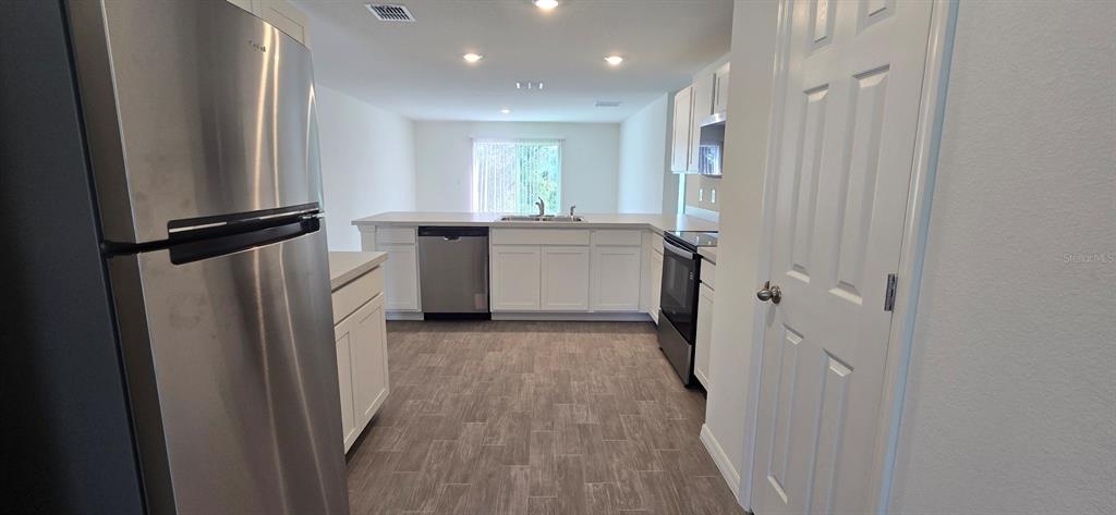 17159 Southwest 42nd Terrace Ocala, FL 34473 - Photo 7 of 17 a view of a kitchen with a refrigerator and a sink