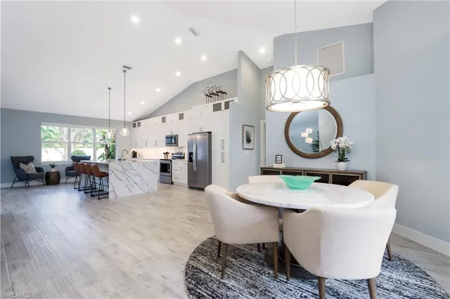 a living room with furniture kitchen view and a mirror
