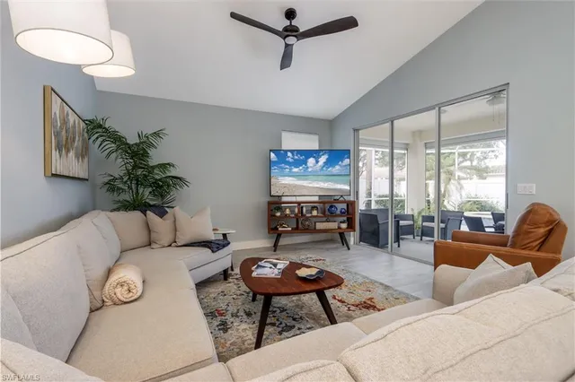 a living room with furniture a flat screen tv and a large window
