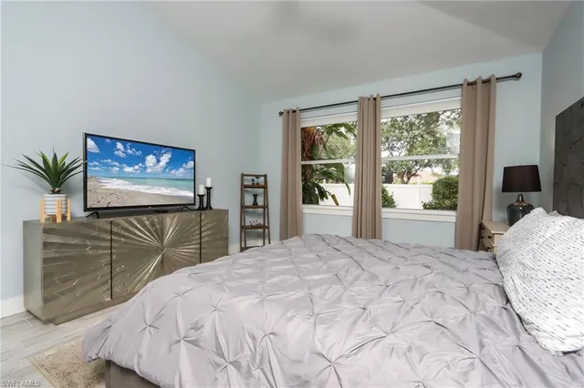a bedroom with a large bed and a flat screen tv