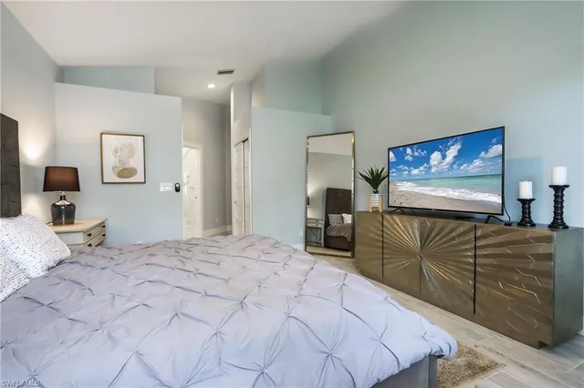 a bedroom with a bed and a flat screen tv