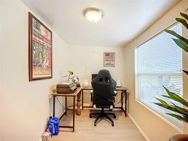 a view of a workspace with furniture and a window