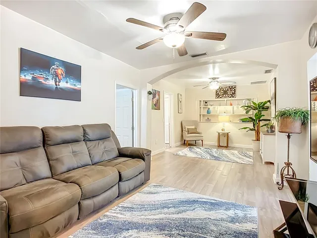 a living room with furniture wooden floor and a chandelier