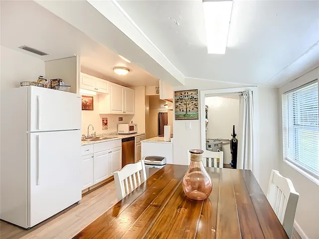 a kitchen with a refrigerator and wooden floor