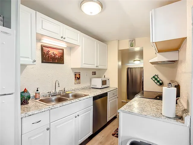 a kitchen with a sink appliances and cabinets