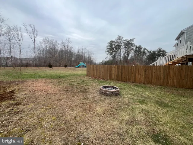 a view of a backyard with wooden fence