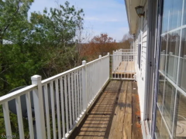 a view of balcony with wooden floor and fence