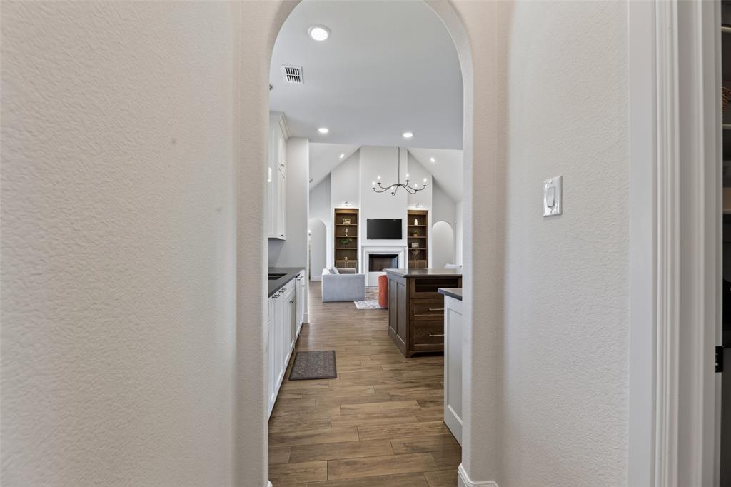 11032 Gregory Road Sanger, TX 76266 - Photo 24 of 40 Archway entry to an open-concept interior with vaulted ceilings, recessed lighting, wood-finish flooring, and a central island
