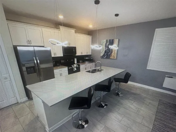 a kitchen with stainless steel appliances a table chairs and a refrigerator