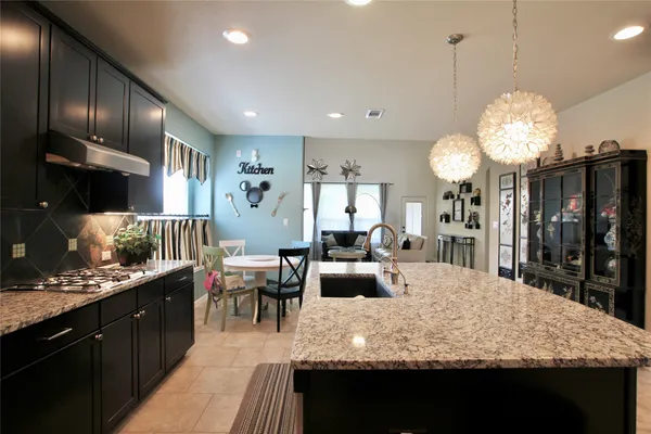 a large kitchen with a large counter top appliances and cabinets