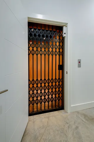 a kitchen with stainless steel appliances a dining table chairs microwave and cabinets