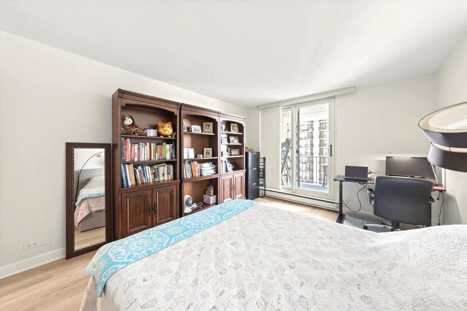6033 North Sheridan Road, Unit 9E Chicago, IL 60660 - Photo 15 of 23 a bedroom with a bed and a dresser with bookshelf