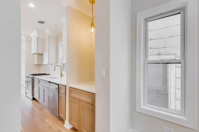 a large kitchen with granite countertop a large counter top a sink stainless steel appliances and cabinets