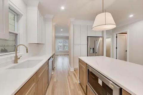 a kitchen with a sink a counter space and a refrigerator