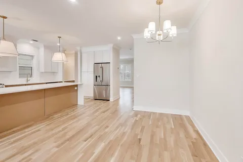 a view of a kitchen with a sink dishwasher a refrigerator and wooden floor