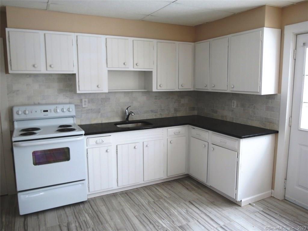 13 Wilcox Street Wethersfield, CT 06109 - Photo 13 of 21 a kitchen with granite countertop white cabinets and white appliances