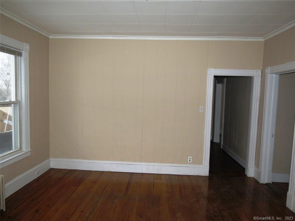 13 Wilcox Street Wethersfield, CT 06109 - Photo 9 of 21 an empty room with wooden floor and windows with curtains