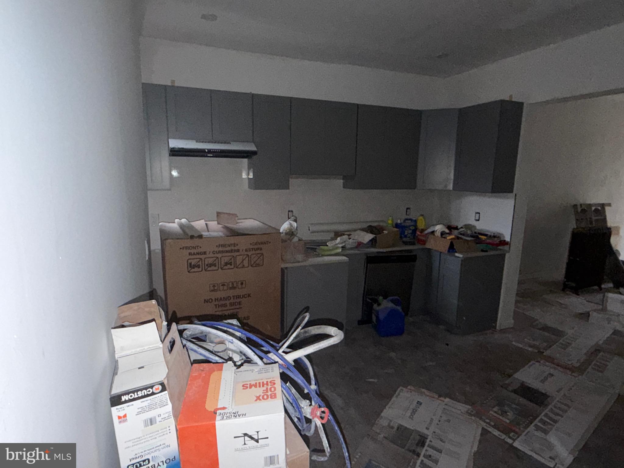 5609 Wyalusing Avenue Philadelphia, PA 19131 - Photo 9 of 36 a storage room with water heater and wooden cabinets