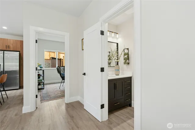 a view of a hallway with wooden floor windows and a living room