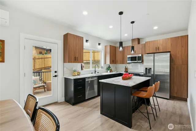a kitchen with kitchen island a sink stove and refrigerator