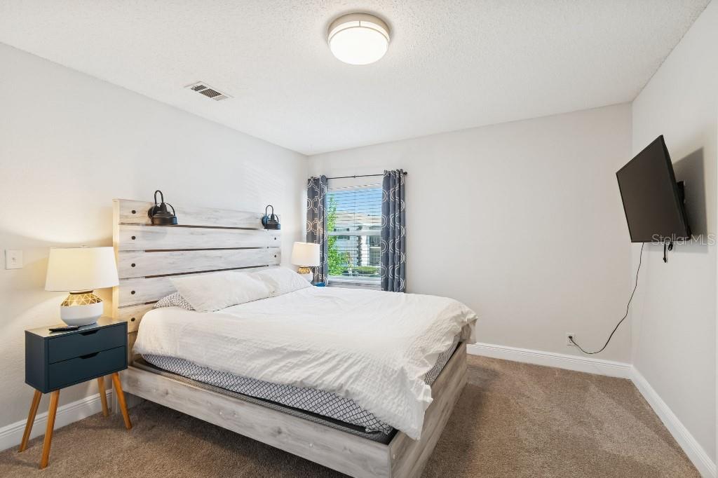 13125 Wilcox Road, Unit 6205 Largo, FL 33774 - Photo 19 of 48 a bedroom with a bed and a flat screen tv