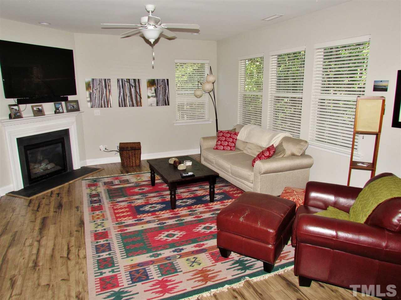 5713 Spring Glen Lane Raleigh, NC 27616 - Photo 3 of 25 a living room with furniture a flat screen tv and a fireplace