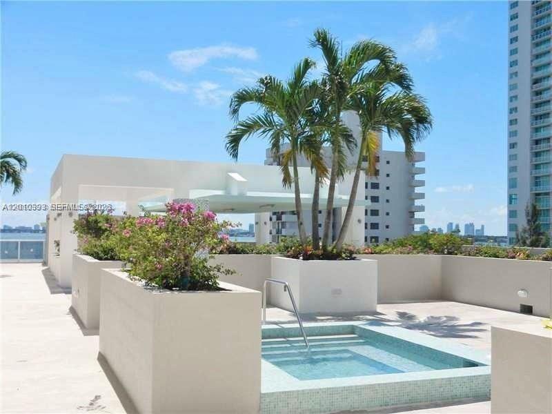 600 Northeast 27th Street, Unit 2001 Miami, FL 33137 - Photo 16 of 20 a view of a white house with a potted plants and palm tree