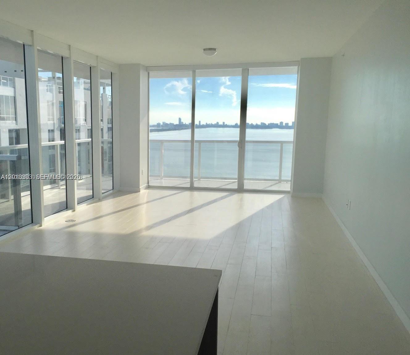 600 Northeast 27th Street, Unit 2001 Miami, FL 33137 - Photo 5 of 20 an empty room with wooden floor and windows