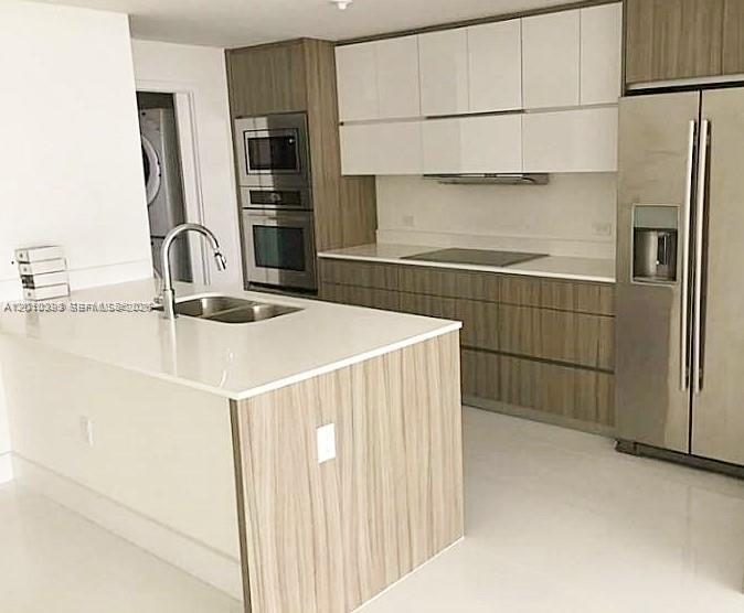 600 Northeast 27th Street, Unit 2001 Miami, FL 33137 - Photo 7 of 20 a kitchen with stainless steel appliances a refrigerator and cabinets