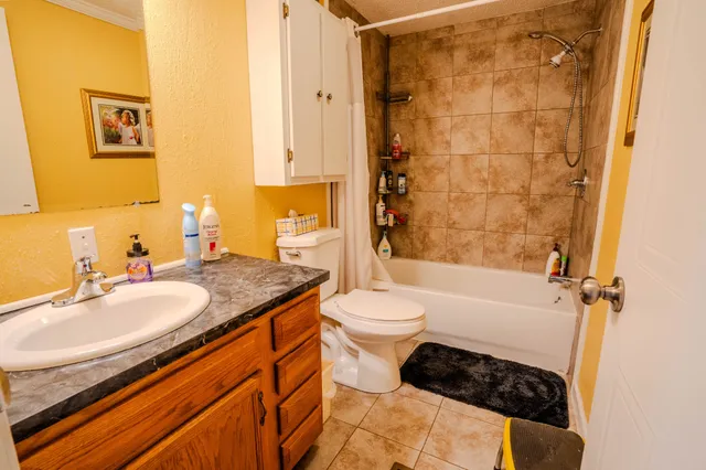 a living room with furniture a flat screen tv and white walls