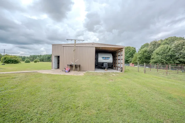 a view of a house with a big yard and large trees