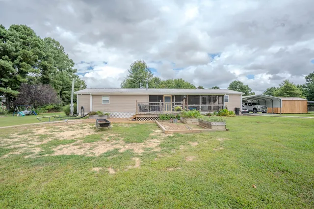 a backyard of a house with plants and palm tree