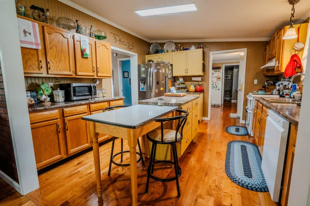 a view of a dining room with furniture a flat screen tv and wooden floor
