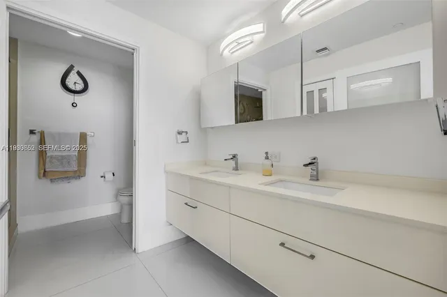 a spacious bathroom with a double vanity sink a mirror and a bathtub