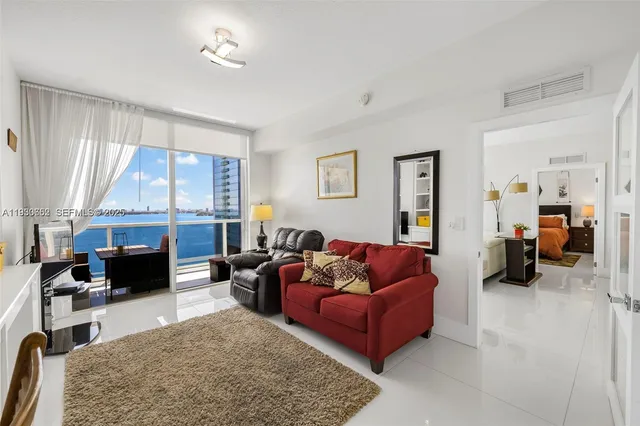 a living room with furniture fireplace and a large window