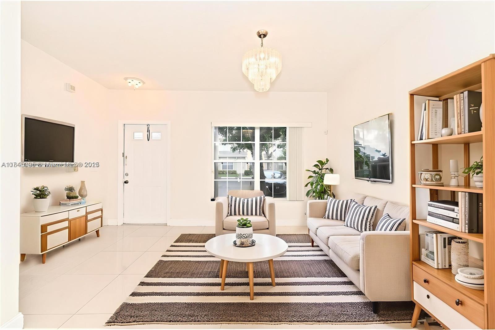 69 Simonton Circle, Unit 1 Weston, FL 33326 - Photo 2 of 23 a dining room with furniture and a flat screen tv