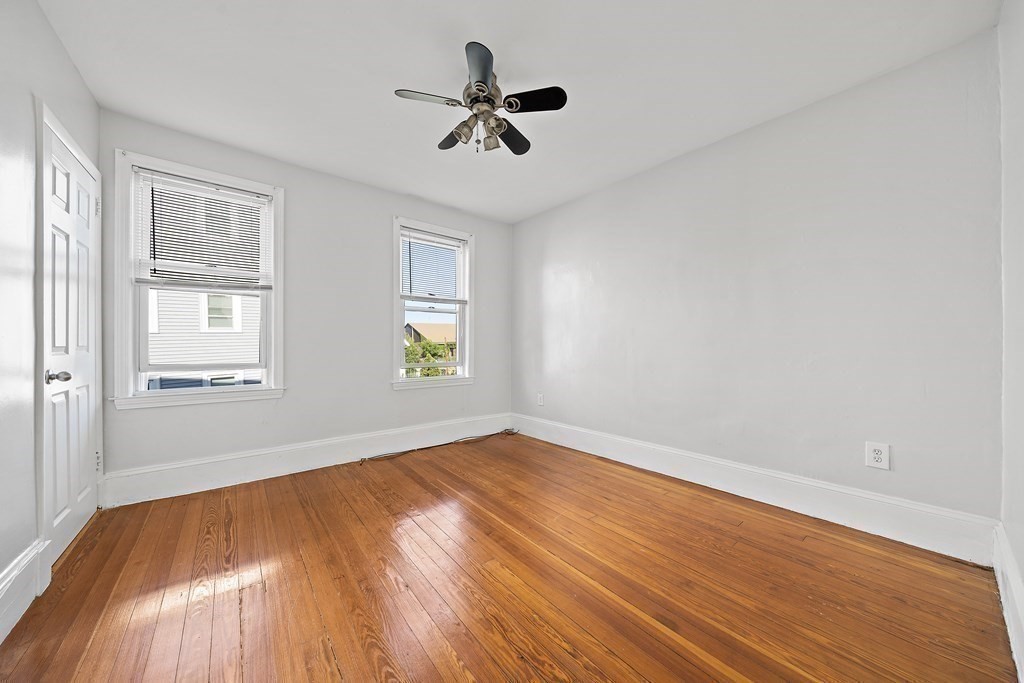 7 Tolman Street, Unit 2 Boston, MA 02122 - Photo 11 of 13 wooden floor in an empty room with a window