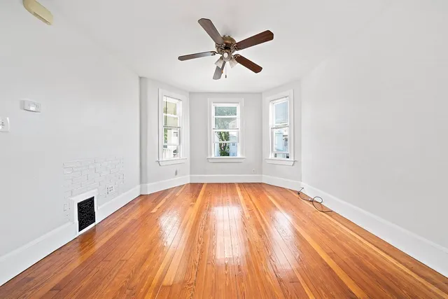 wooden floor in an empty room with a window