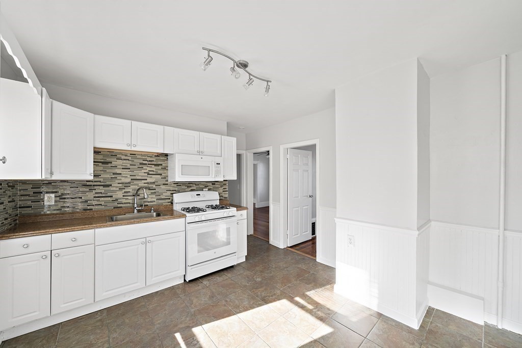 7 Tolman Street, Unit 2 Boston, MA 02122 - Photo 7 of 13 a kitchen with white cabinets and white appliances