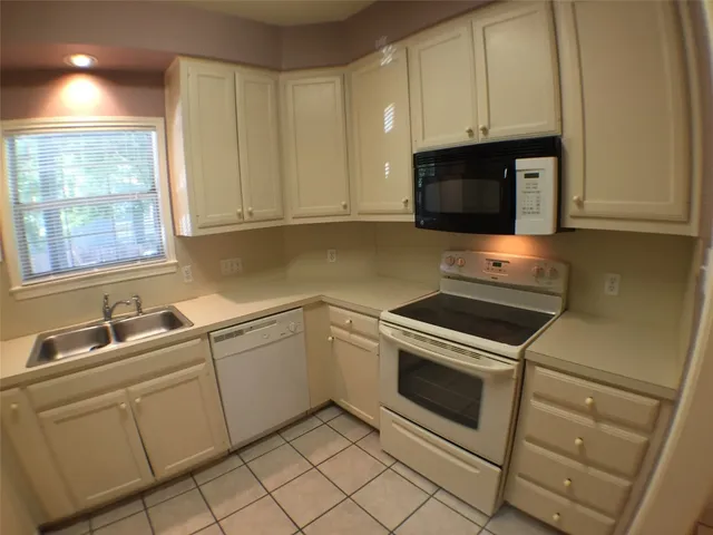 a kitchen with cabinets appliances and a sink