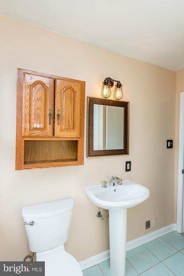 6112 Mt Ridge Road Baltimore, MD 21228 - Photo 19 of 30 a bathroom with a toilet sink and mirror