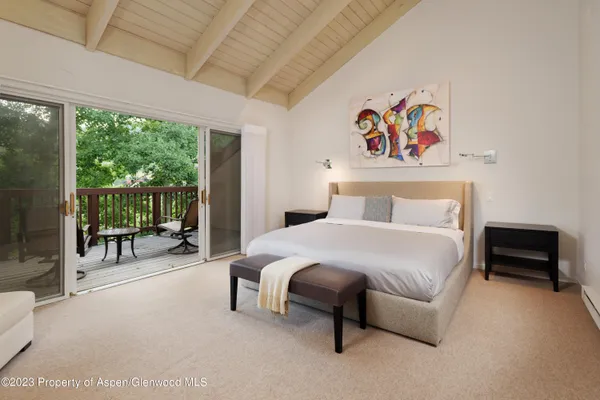 a bedroom with a bed and a large window with balcony view