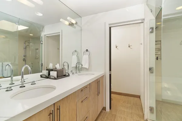 a bathroom with double vanity sinks and a mirror