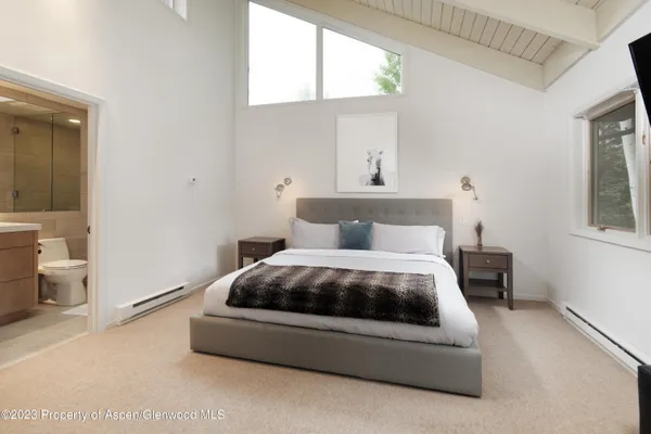 a spacious bedroom with a bed and a window