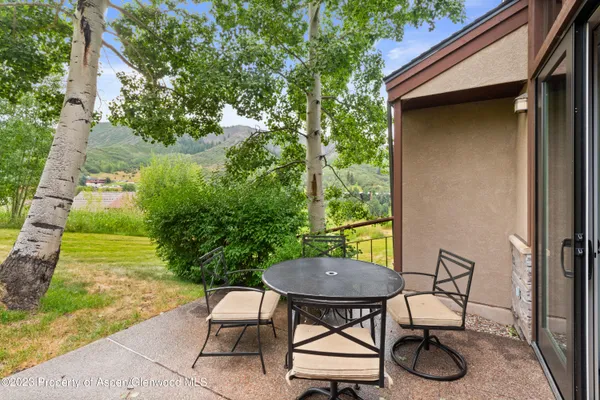 a view of a chairs and table in backyard of the house
